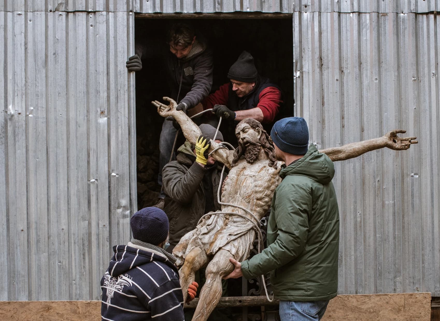 People moving a religious statue to protect it from wartime destruction